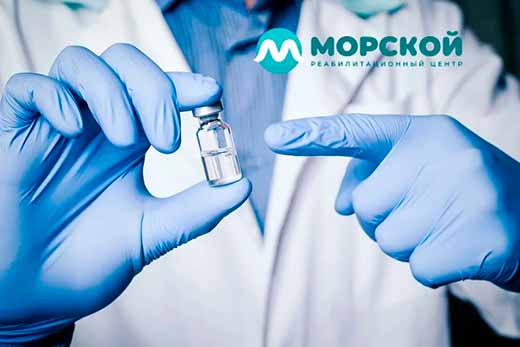 Врач держит флакон с лекарством и указывает на него