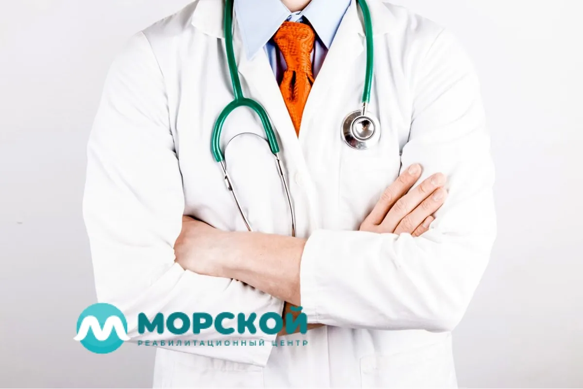 Врач стоит скрестив руки