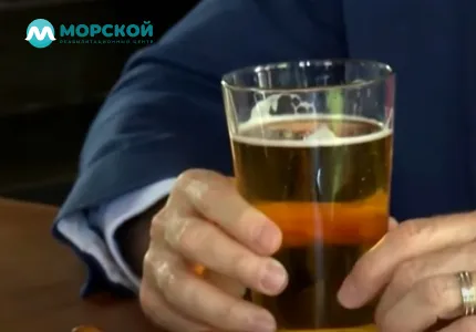 Мужчина держит в руке стакан пива